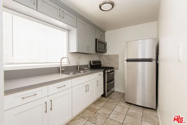 a kitchen with white cabinets and white appliances