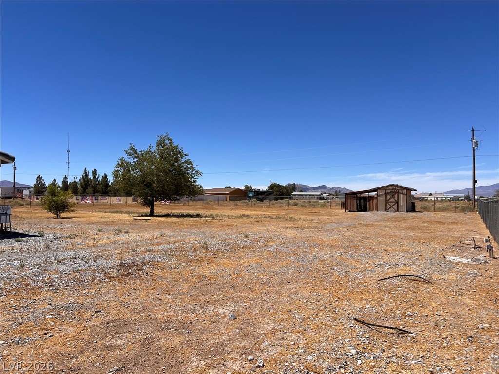 200 East Gamebird Road Pahrump, NV 89048 - Photo 21 of 23 A spacious, open parcel awaits your vision, complete with mature trees and a rustic shed.