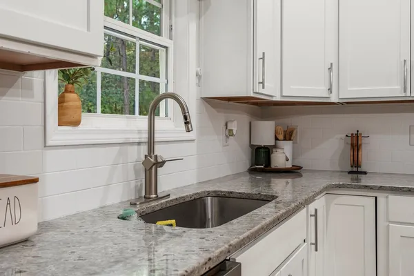 a kitchen with granite countertop a sink and a window