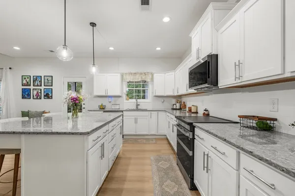 a large kitchen with granite countertop lots of counter space and window