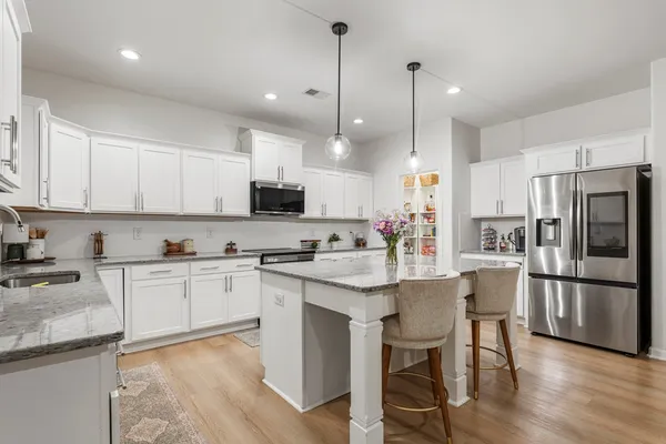 a kitchen with kitchen island granite countertop a sink a center island and stainless steel appliances