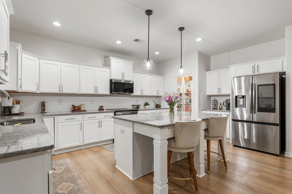 84 Dunley Court Ellerslie, GA 31807 - Photo 19 of 44 a kitchen with kitchen island granite countertop a sink a center island and stainless steel appliances