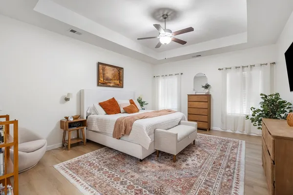 a spacious bedroom with a bed and a chandelier