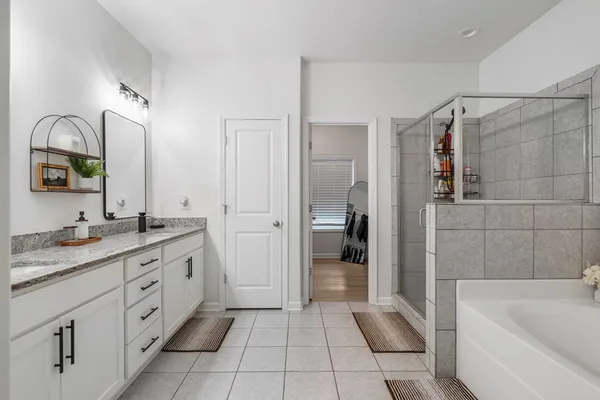 a bathroom with a tub sink and mirror