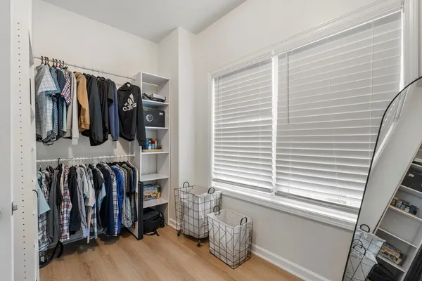 a view of walk in closet with clothes and shoes