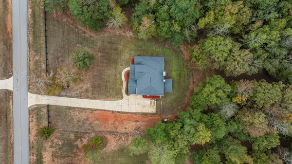 an aerial view of a house with a yard and basket ball court