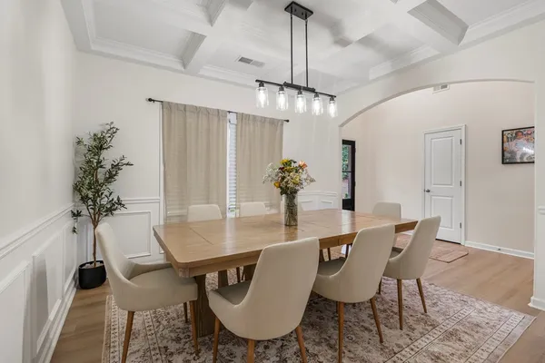 a dining room with furniture potted plants and wooden floor