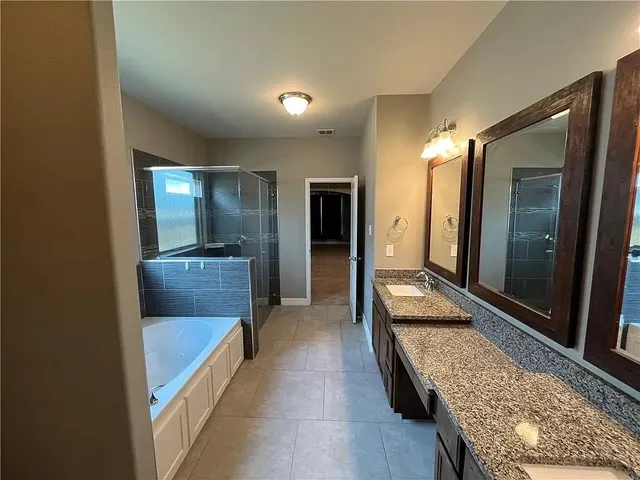 a bathroom with a granite countertop toilet sink and mirror
