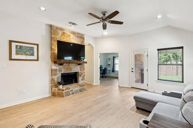 a living room with furniture a flat screen tv and a fireplace
