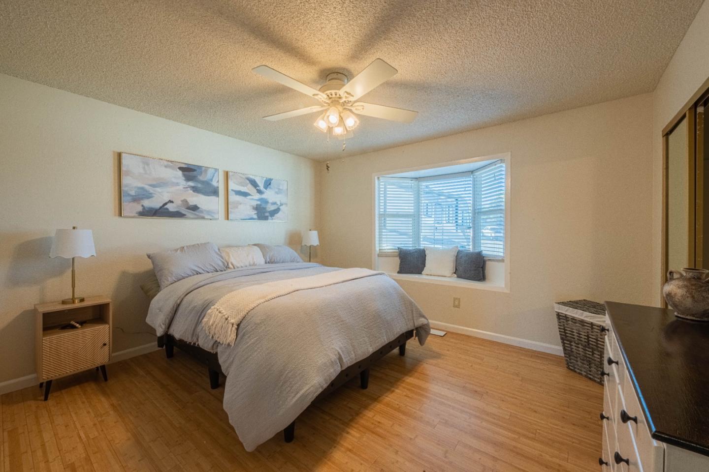 9919 Mimosa Path Salinas, CA 93907 - Photo 26 of 39 a bedroom with a large bed a chandelier and a window
