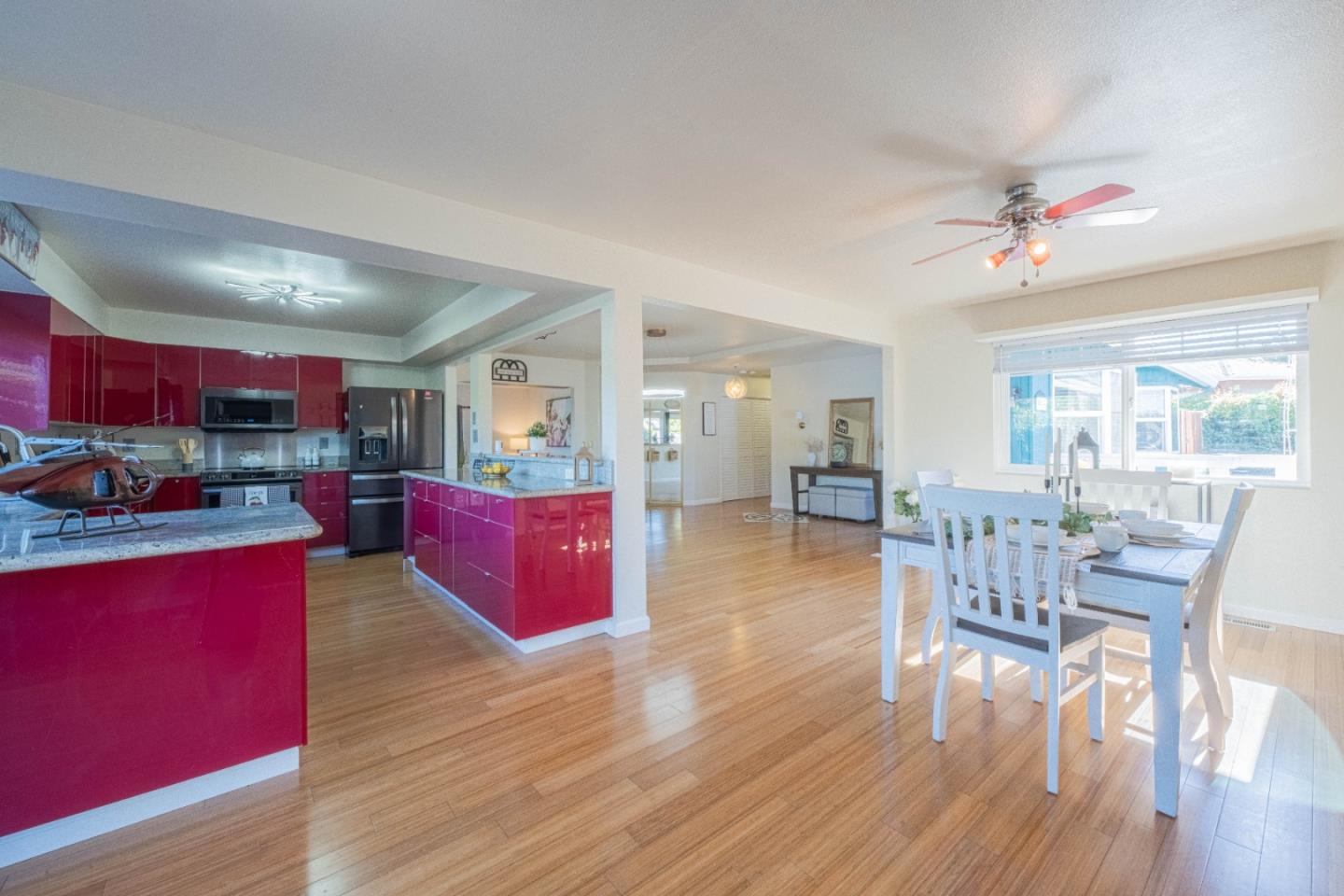 9919 Mimosa Path Salinas, CA 93907 - Photo 7 of 39 a kitchen with stainless steel appliances kitchen island granite countertop wooden floors and a view of living room