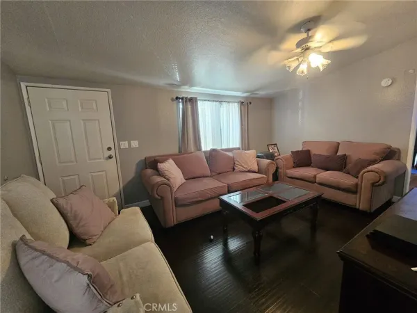 a living room with furniture a chandelier fan and a window