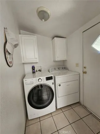a utility room with cabinets washer and dryer