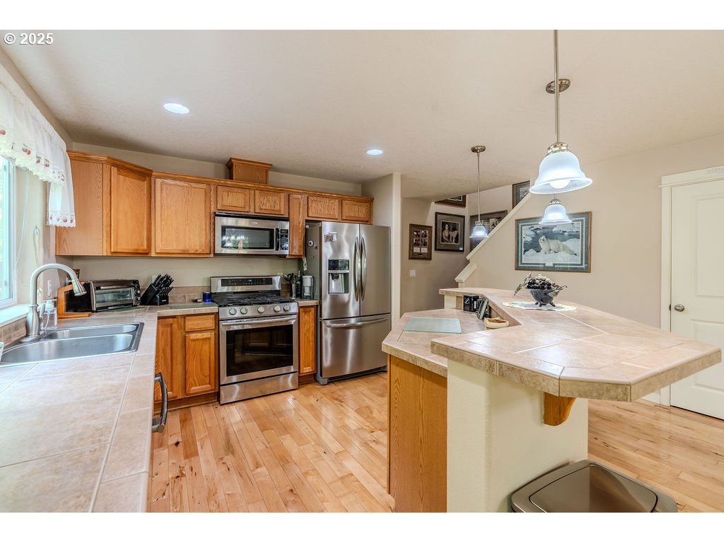 37702 Hamilton Ridge Drive Sandy, OR 97055 - Photo 12 of 44 a kitchen with stainless steel appliances granite countertop a sink a stove and a refrigerator