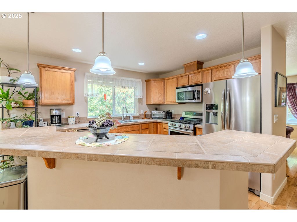 37702 Hamilton Ridge Drive Sandy, OR 97055 - Photo 14 of 44 a kitchen with stainless steel appliances granite countertop a sink refrigerator and window