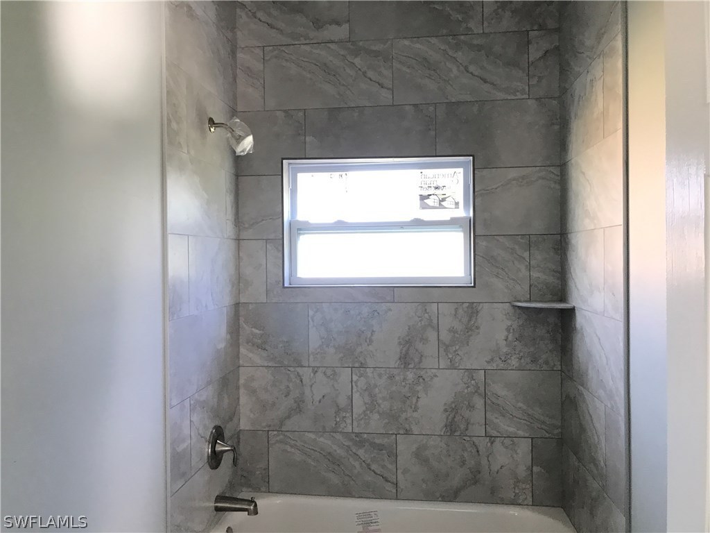 3403 35th Street Southwest Lehigh Acres, FL 33976 - Photo 6 of 7 a bathroom with a window and a shower