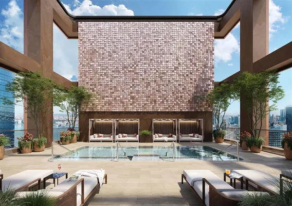 a view of a patio with couches and a fire pit and wooden fence