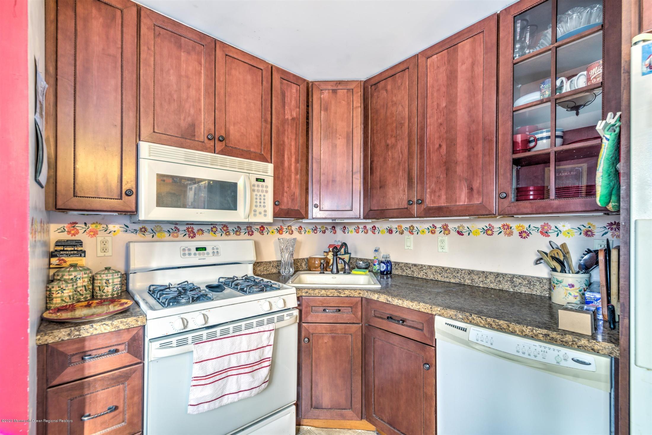 60 Mallard Road Bayville, NJ 08721 - Photo 7 of 20 a kitchen with stainless steel appliances granite countertop wooden cabinets a stove and a sink