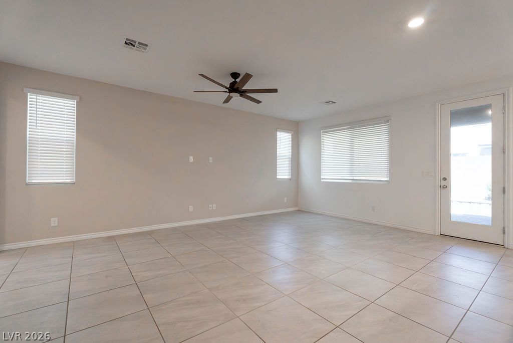 7126 Calvert Cliffs Street North Las Vegas, NV 89084 - Photo 6 of 44 A spacious living area awaits, featuring durable tile flooring and access to the outdoors.