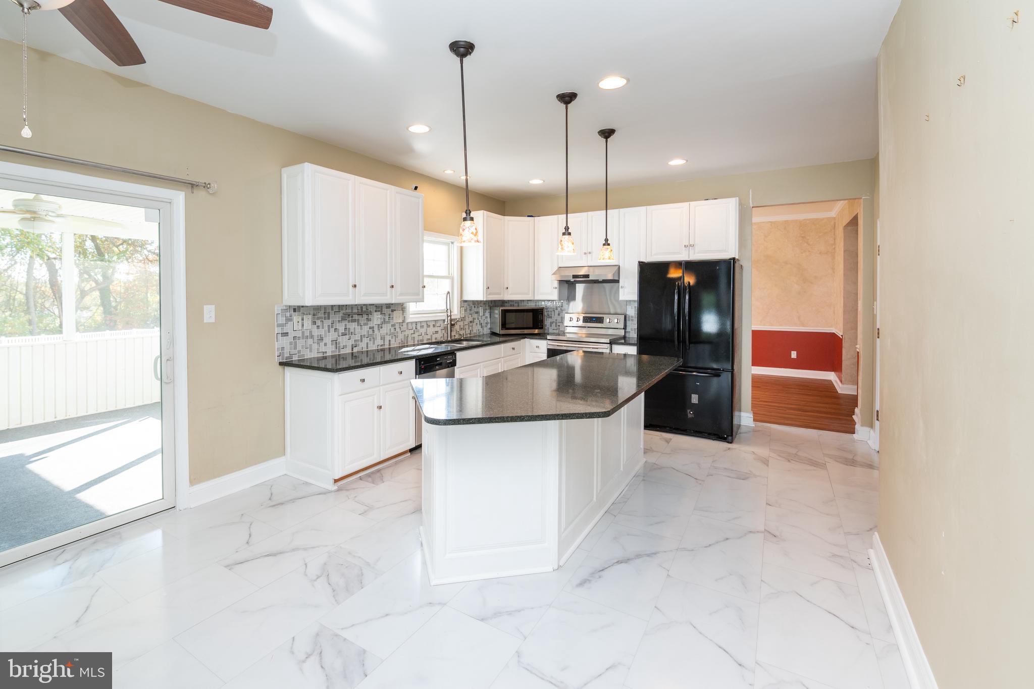 128 Jillian Court Dover, DE 19901 - Photo 15 of 45 a large kitchen with stainless steel appliances kitchen island granite countertop a sink a counter space and a window