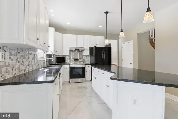 a kitchen with stainless steel appliances granite countertop a sink a stove and a refrigerator