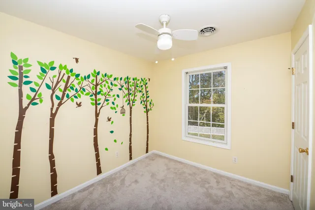 a view of a bedroom with a window and ceiling fan