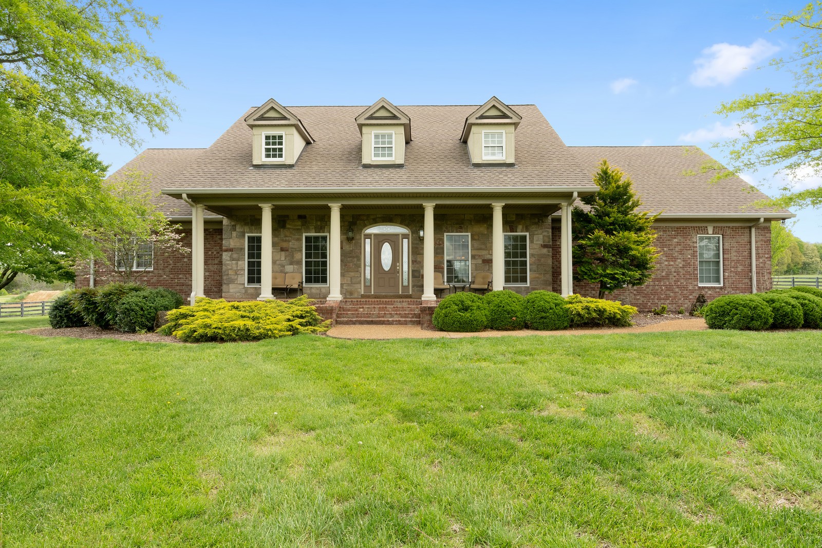 288 Lee Road Cottontown, TN 37048 - Photo 1 of 47 a view of a white house with a large windows and a yard with plants and large trees