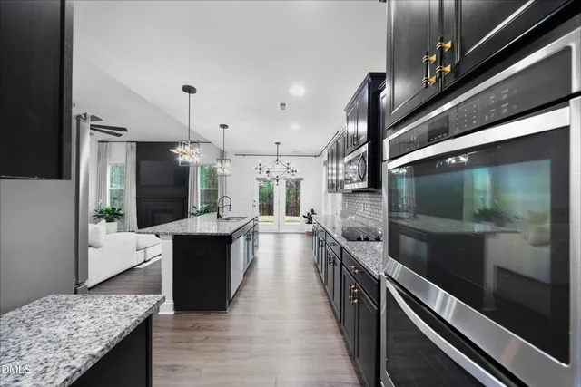 a large kitchen with stainless steel appliances kitchen island granite countertop a large counter top and wooden floor
