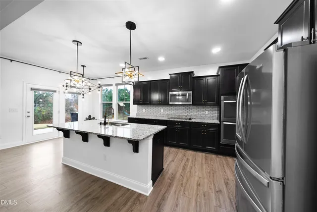a kitchen with stainless steel appliances granite countertop a sink refrigerator and microwave
