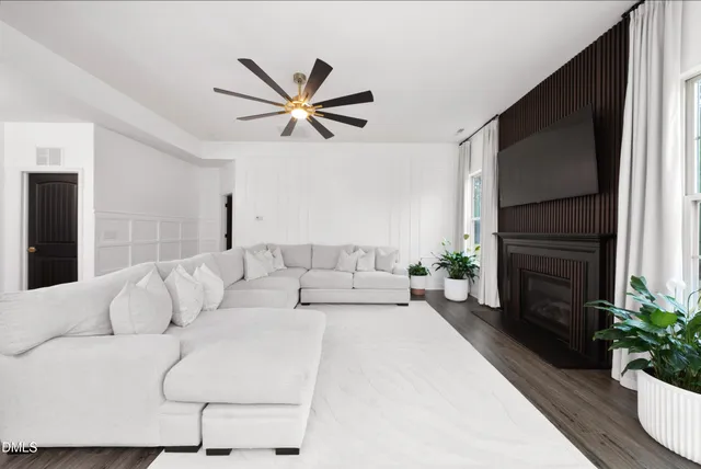 a living room with furniture a fireplace and a potted plant
