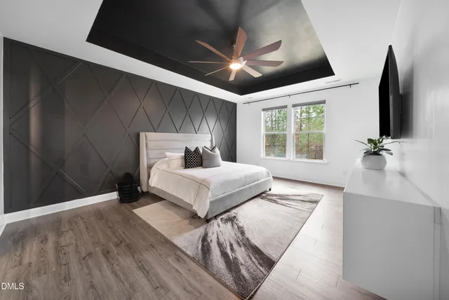 a bedroom with a bed and a flat tv screen on a dresser