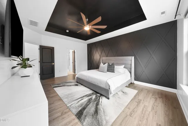 a bedroom with a large bed and a chandelier