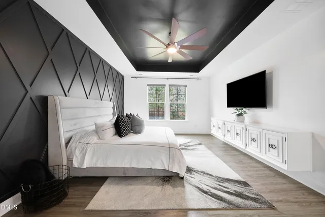 a bedroom with a bed television on wall and a flat screen tv