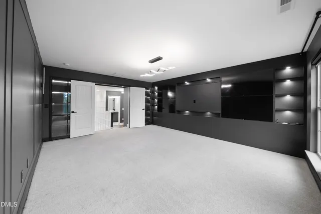 a view of an empty room with window and fireplace