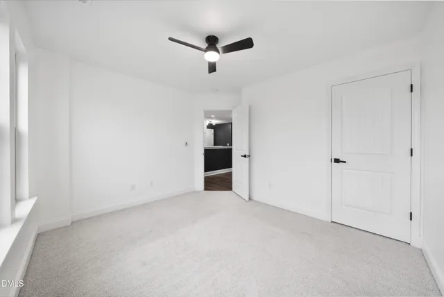 an empty room with chandelier fan