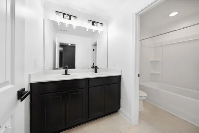 a view of a chandelier in big room and a bathroom