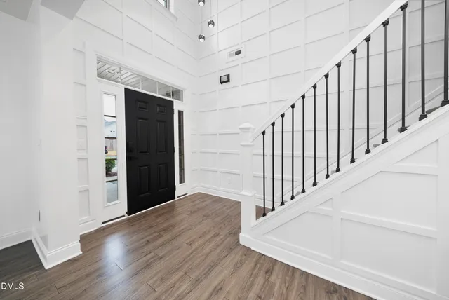 a view of a hallway with wooden floor and staircase