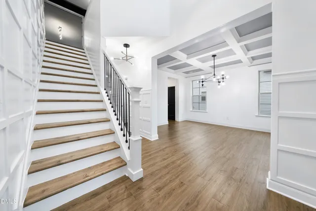 a view of a hallway with wooden floor and staircase