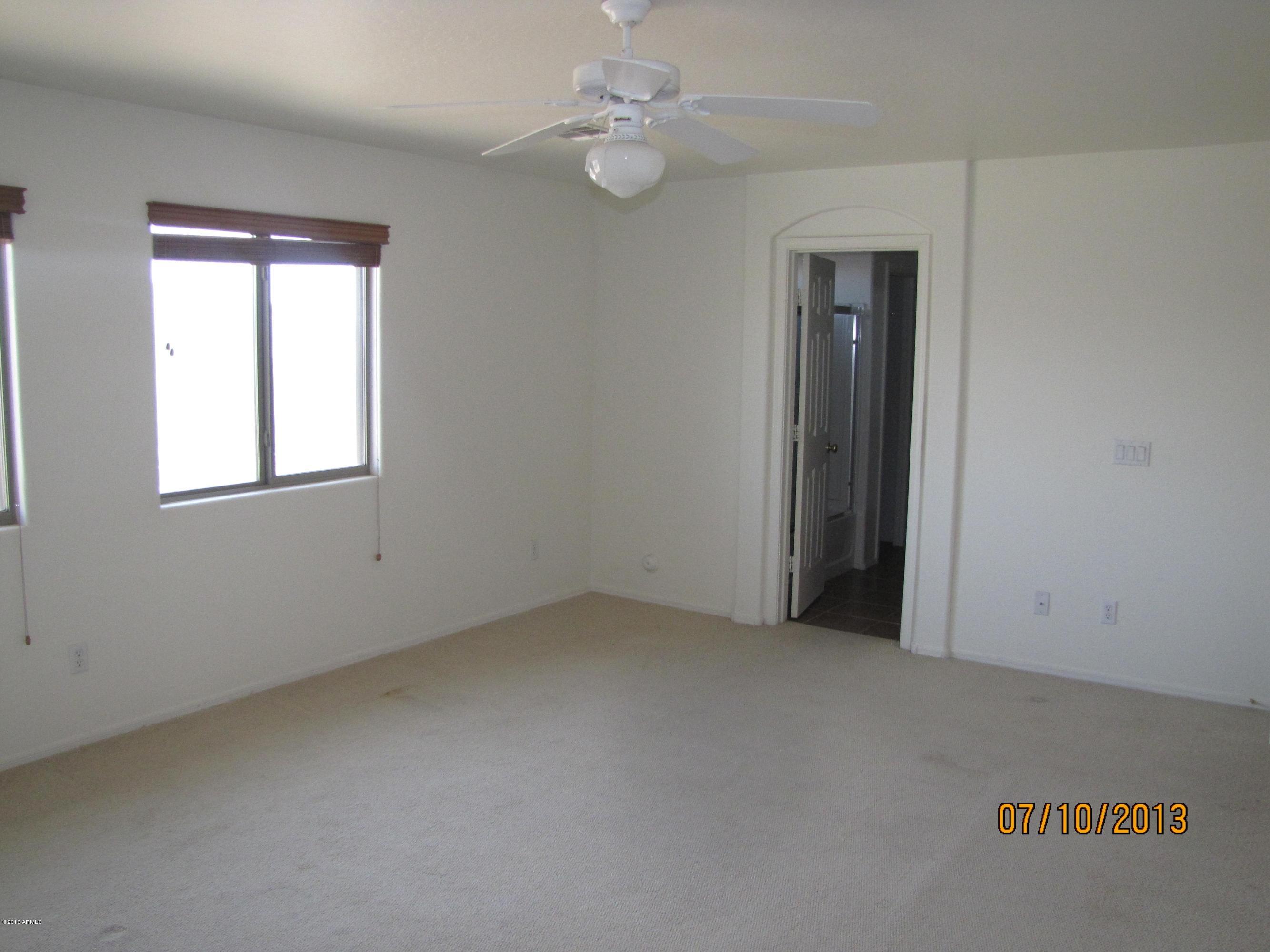 44134 Roth Road Maricopa, AZ 85138 - Photo 7 of 13 an empty room with a window and ceiling fan