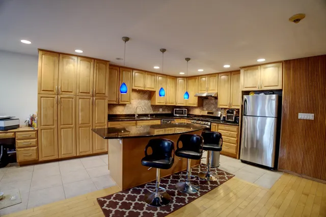 a kitchen with refrigerator and chairs