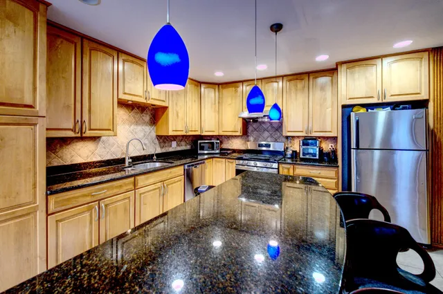 a kitchen with stainless steel appliances granite countertop a refrigerator sink and cabinets