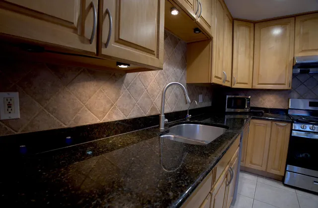 a kitchen with stainless steel appliances granite countertop a stove and a microwave