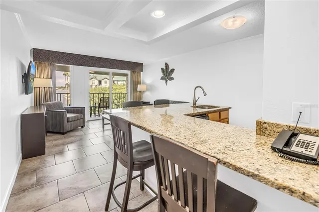 a kitchen with granite countertop sink table and chairs