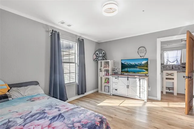 a bedroom with a bed and a flat tv screen on the dresser