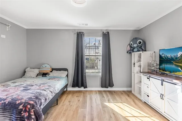 a bedroom with a bed and wooden floor