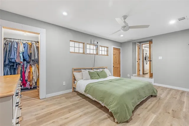 a bedroom with a large bed and a flat tv screen on dresser