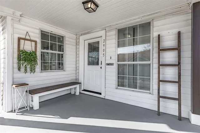 a view of an empty room with wooden floor and windows