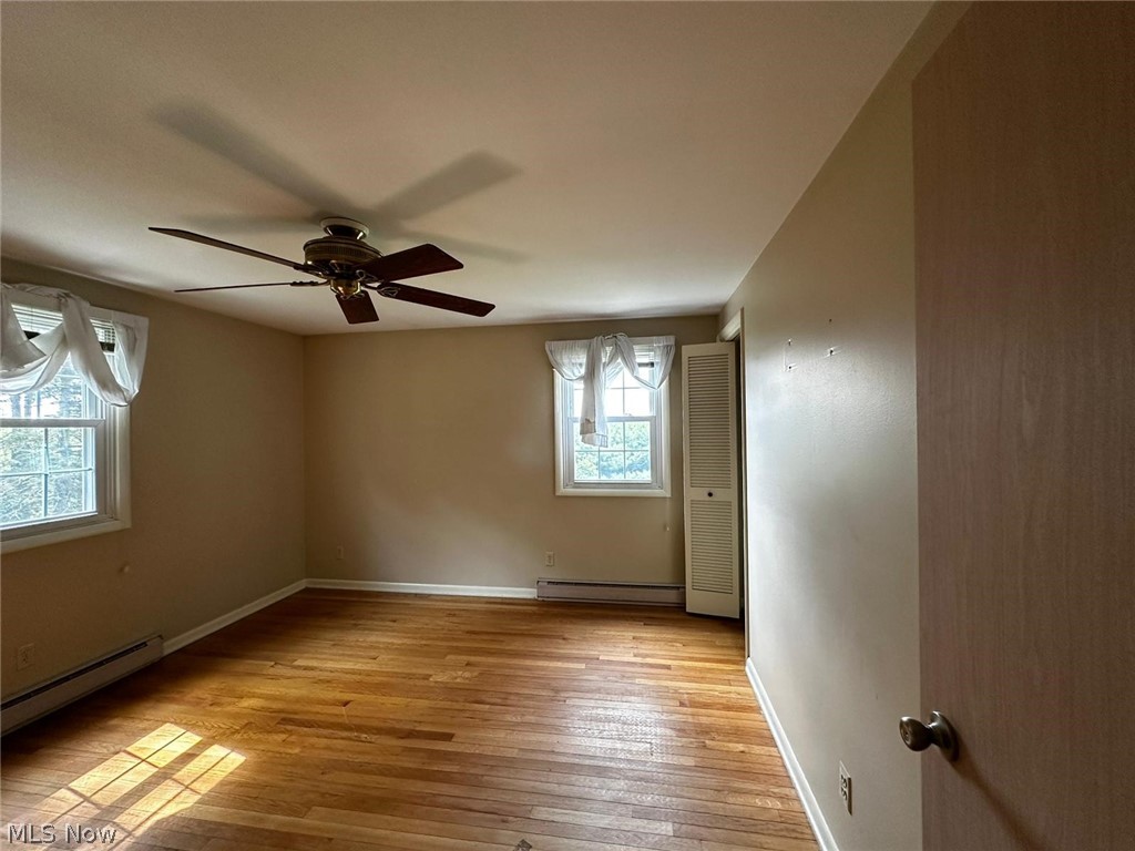 2093 Cambridge Road Coshocton, OH 43812 - Photo 22 of 32 Spare room featuring ceiling fan, light wood-type flooring, and a baseboard heating unit