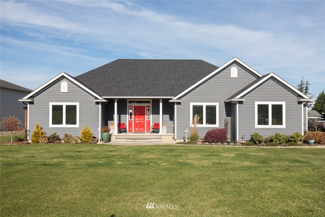 a front view of house with yard and trees in the background
