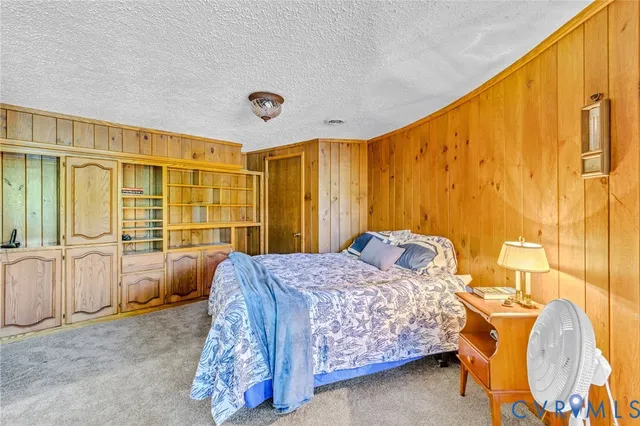 a bedroom with a bed and large windows